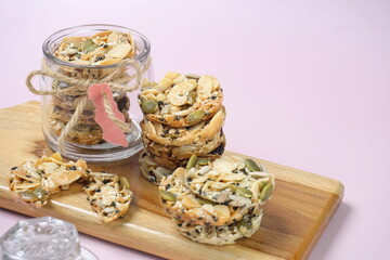 Celebration cookies, Florentine cookies in a glass jar and wooden board . Gluten free biscuits made from mixed nuts and dried fruits as a healthy choice. 