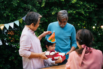 Obraz premium Asian family celebrate kid birthday party together outdoor at yard.