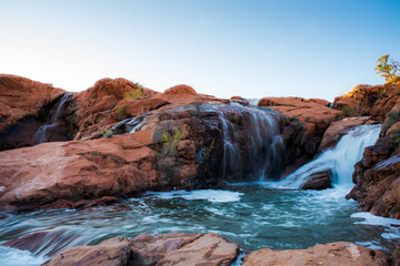 Waterfalls flowing over red sandstone, Gunlock Falls, UT