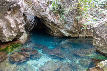 Cave in the water. A crystal clear water seeing through all the rocks on the floor.