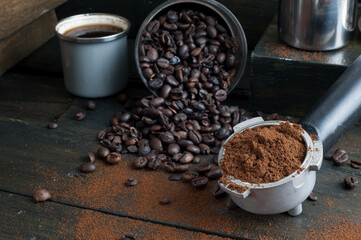 coffee bean cup and porta filter with coffee powder inside and Vietnam Drip Coffee on wooden table