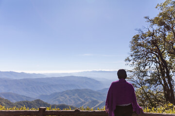 Fototapeta na wymiar Behind the young woman on Beautiful landscape of 1715 viewpoint at Doi Phu Kha national park in Pua District, Nan province, THAILAND.