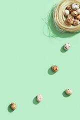 Quail eggs in straw nest. Top view spring Easter holiday background.