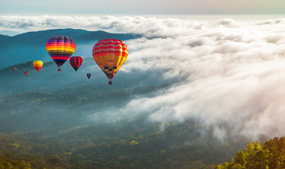 Fototapeta na wymiar Colorful hot-air balloons flying over the mountain and sea of mist, Doi Inthanon Natural Park Chiang Mai, Thailand