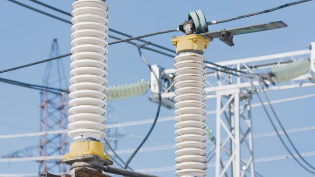 Power poles on background of blue sky. Action. Beautiful electric poles on blue sky background. Electrical substation with poles and cables. Power generation and transmission industry