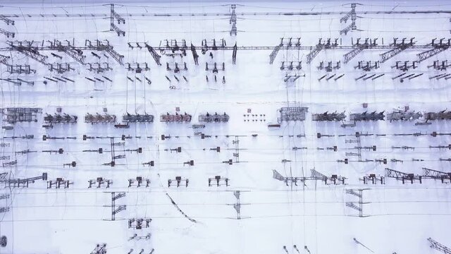 Electric station poles in winter. Action. Top view of modern electrical substation with rows of transformers in winter. Rows of electric poles at station