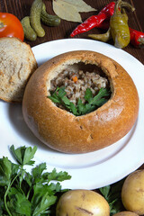 A traditional dish of Russian cuisine is buckwheat in a pot of bread. Restaurant serving concept. Close-up.