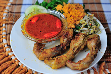 This is Ayam Bakar or Ayam Panggang. Ayam Bakar is one of the favorite dishes in Indonesia. Half-cooked chicken with spices then grilled over charcoal