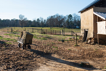 Old farm house and trailer with hay.