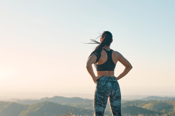 Portrait of proud woman in sporty clothes with her hands on hips standing after exercising