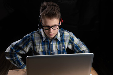 Boy with glasses and shirt on laptop excited