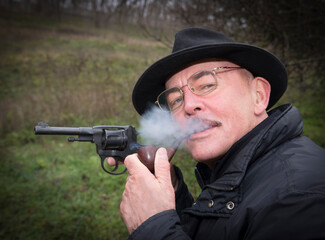 Man with gun  system Nagan smoking his pipe