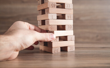 Male hand showing wooden block, Risk. Business