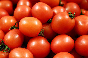 Red cherry tomatoes with green cuttings, fresh vegetables on the market