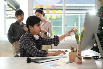 Creative designer team brainstorming and using modern devices in office.