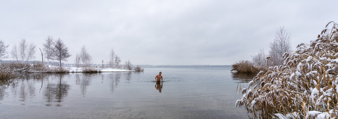 A man goes into a lake in winter for ice swimming