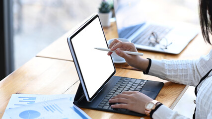 Close up view of businesswoman holding stylus pen pointing on screen of tablet computer at office...