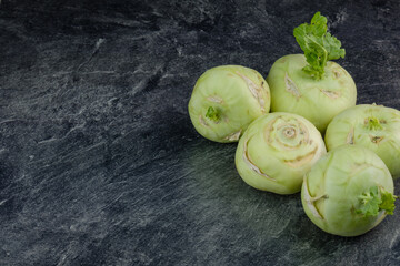 Kohlrabi liegen auf einer dunklen marmorierten Küchen-Arbeitsplatte