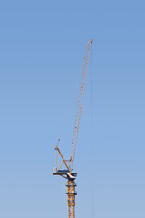 Crane. Construction crane. Huge crane against blue sky. Self-erection cranr. Tower crane.