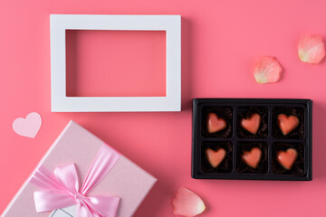 Valentine's Day design concept background with pink petals and gift box.