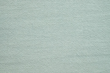 Close-up of Light green color natural fabric cloth texture background. Material is used in the textile assembly. New abstract surface design structure with empty, copy space for wallpaper.