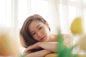 Close up portrait of young asian beauty woman laying on a couch.