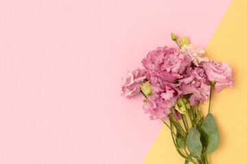 Bouquet of eustoma flowers on a gold and pink background. Gift for Mothers Day, 8 March with copyspace.