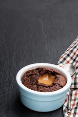 Hot chocolate lava cake in clay pot on black stone background