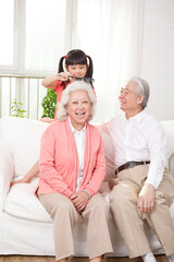 Happy grandparents and grandchildren are playing in the living room 