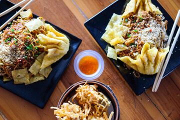 Devil noodle called (Mie Gacoan) equipped with fried dim sum and vegetables toppings