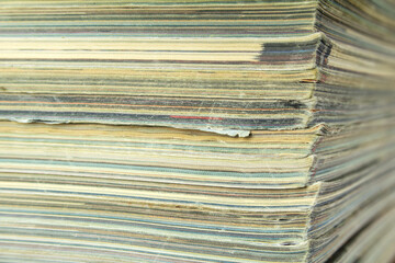 Stack of old shabby magazines. Side view with bokeh effect.