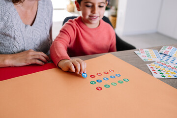 Mother and son making additions ans subtractions with stickers at home