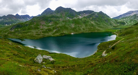 Naklejka na ściany i meble gorgeous mountain lake in a green valley while hiking panorama