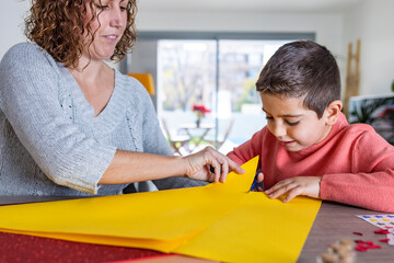 Mother and son  making crafts with cardboards  at home.
