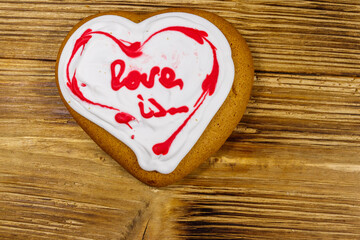 Heart shaped gingerbread cookie on wooden table.  Top view. Dessert for valentine day