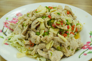 spicy pork salad with garlic and chili and cabbage on white plate