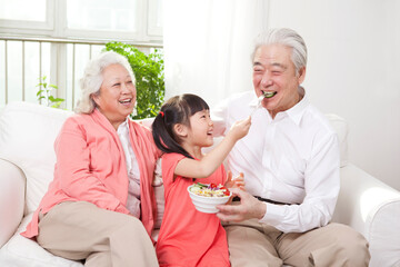 Happy grandparents and grandchildren are playing in the living room