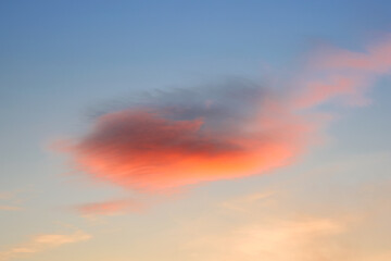 The sky at sunset. A bright red cloud in the evening sky.