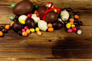 Easter composition with chocolate eggs on wooden background