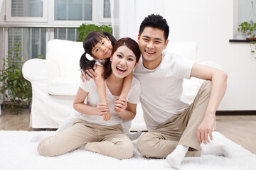 A happy family of three is playing in the living room 