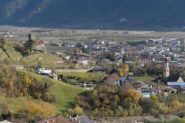Fototapeta premium Panoramic view to the valley of Naturns in South Tyrol in autumn, in the background the snow-covered mountains, blue sky with clouds, no people