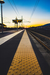 Fototapeta na wymiar Caldo tramonto nella stazione ferroviaria