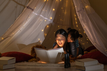 Happy family asian mother and daughter reading a book