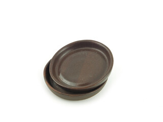 Empty brown old clay saucers stack, for food use home or restaurant isolated on a white background. Kitchen accessory..