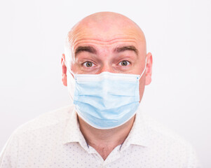 portrait of bald adult elderly man in medical mask with emotions on white background