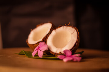 Fototapeta na wymiar Grounded coconut flakes,half coconut with green leaves wooden on background,hd footage of coconut milk and half coconut on wooden