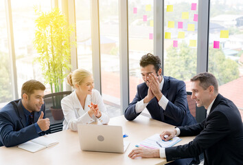 Group of business people are  discussing about the project in the meeting room with smiling face. They are satisfied that project is successful. Partners are clapping hands after business seminar