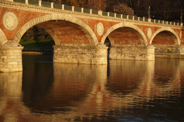 Fototapeta na wymiar Italy: arched bridge over the river in autumn 