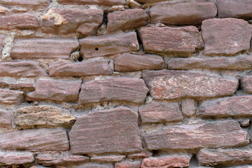 Masonry. Red lumps with cement joints. Round holes. Ancient wall concept.