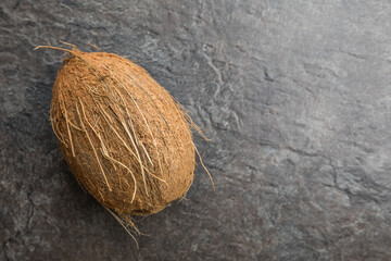 Ganze Kokosnuss auf grauer Schieferplatte